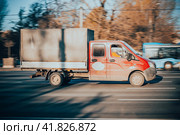 Gazelle truck rides on the road. Red cargo van GAZ Gazelle Next driving in the street with urban autumn background. (2021 год). Редакционное фото, фотограф Константин Григорьев / Фотобанк Лори