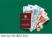 Пенсионное удостоверение гражданина Российской Федерации, рублевые банкноты и монеты на зеленом фоне. Социальные выплаты пенсионерам. Стоковое фото, фотограф Виктория Катьянова / Фотобанк Лори