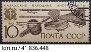Почтовая марка с гашением СССР 1990 год. Казахские народные инструменты. Домбра, Кобыз, Сыбызгы, Даулпаз. (2023 год). Редакционное фото, фотограф Елена Бобкова / Фотобанк Лори