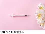 Flowers and medical syringe on pink background. Minimal concept of beauty injections. Selective focus. Стоковое фото, фотограф Клара Мухаметзянова / Фотобанк Лори