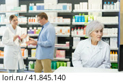 Old female pharmacist looking at display of computer in chemist's shop. Стоковое фото, фотограф Яков Филимонов / Фотобанк Лори