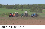 Трактора Кировец, New holland, john deere в поле разбрасывают органические удобрения (2022 год). Редакционное видео, видеограф Владислав Кашеваров / Фотобанк Лори