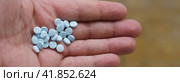 A handful of blue pills with a man's hand. Warfarin, anticoagulant (blood thinner). The topic of drug treatment. Стоковое фото, фотограф YuryKara / Фотобанк Лори