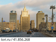 Moscow, Russia - February 5, 2021: Cityscape in winter day. Stalinist architecture building of Ministry of foreign affairs (MFA) and Borodinsky Bridge. Smolenskaya subway station. Редакционное фото, фотограф YuryKara / Фотобанк Лори