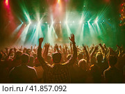 People having fun and dancing with their hands up at a concert in a nightclub.Entertainment at a party. Стоковое AI-изображение, AI-художник Коханова Наталья / Фотобанк Лори