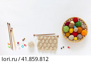 Composition of accessories for hand knitting: wooden knitting needles, row counter, multi-colored balls of woolen yarn in basket and a sample for knitting a warm scarf for autumn. DIY concept, copy space. Стоковое фото, фотограф Виктория Катьянова / Фотобанк Лори