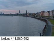 Dusseldorf, Germany - June 3, 2019: Dusseldorf embankment in Altstadt at cloudy blue sunset. Schlossturm (maritime museum) or castle tower on  Burgplatz, St. Lambert church, Oberkasseler Brücke. Редакционное фото, фотограф YuryKara / Фотобанк Лори
