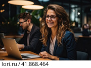 A young beautiful girl with long hair is sitting in a spacious office at a laptop and smiling. Generated by AI. Стоковое AI-изображение, AI-художник Ярославский Максим / Фотобанк Лори