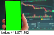 Black phone with blank mockup screen on rising stock graph. Closeup hand showing smartphone isolated green display, Online banking, Fund App use. Financial analyst on Invest Market, Bank collapse 2023. Стоковое видео, видеограф Марина Демидюк / Фотобанк Лори
