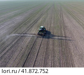 Tractor with hinged system of spraying pesticides. Fertilizing with a tractor, in the form of an aerosol, on the field of winter wheat. Стоковое фото, фотограф Леонид Еремейчук / Фотобанк Лори