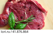 Red meat top view. Cut steak is spinning on wooden Cutting board background. Flat lay. Fresh raw meat with spices and herbs. Black Angus Prime Meat Steaks T-bone, New York, Ribeye and seasoning. Стоковое видео, видеограф Марина Демидюк / Фотобанк Лори