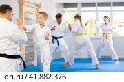 Boy is paired with man teacher to learn how to strike and rehearses blocking opponent. Стоковое фото, фотограф Яков Филимонов / Фотобанк Лори