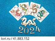 Новый год 2024. Символ года дракон, цифра 2024 и набор почтовых марок с драконами на синем фоне (2023 год). Редакционное фото, фотограф Елена Бобкова / Фотобанк Лори