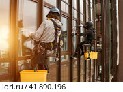 Industrial mountaineering workers hangs over residential facade building. Стоковое фото, фотограф Aleksandr Golubev / Фотобанк Лори