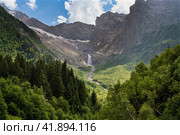 Waterfall flowing down from the mountain range and the Dzhuguturluchat glacier in the mountains of the North Caucasus near the village of Dombay on a sunny summer day, Karachay-Cherkessia, Russia. Стоковое фото, фотограф Ula Ulachka / Фотобанк Лори