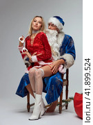 Dirty Santa Claus with sexy girl on his lap sitting on a chair. Стоковое фото, фотограф Гурьянов Андрей / Фотобанк Лори