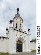 Старица, Тверская область, Россия, август 2021 года. Надвратная часовня и металлические ворота с надписью и рисунками православной тематике над входом в Старицкий Свято-Успенский мужской монастырь. Редакционное фото, фотограф Сергей Никифоров-Гордеев / Фотобанк Лори