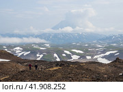View from Gorely volcano to Vilyuchinsky volcano, Kamchatka Krai, Far East of Russia. Hikers on a mountain path. Travel and tourism on the Kamchatka Peninsula. Hiking in the wilderness. Редакционное фото, фотограф Андрей Степанов / Фотобанк Лори