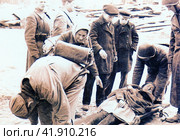 Бойцы санитарной дружины оказывают помощь раненому на одной из городских улиц. Блокадный Ленинград, 1941 год. Редакционное фото, фотограф Сергей Елизарьев / Фотобанк Лори