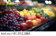 Fresh ripe fruits on the refrigerated storefront. The concept of fruit freshness. Стоковое AI-изображение, AI-художник Ярославский Максим / Фотобанк Лори