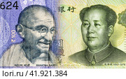 Portraits of Mahatma Gandhi on Indian rupees and Mao Zedong on chinese yuanes. Business concept. Стоковое фото, фотограф FotograFF / Фотобанк Лори
