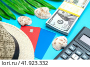 Платежные карты МИР и VISA с соломенной шляпой пачкой долларов и калькулятором на голубом фоне. Концепция отпускных расходов. Стоковое фото, фотограф Ярославский Максим / Фотобанк Лори