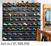 On black wooden wall of showcase - there are samples of models of hiking and climbing shoes (2023 год). Редакционное фото, фотограф Яков Филимонов / Фотобанк Лори