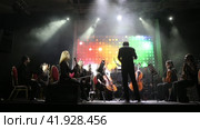 Concert of the symphony orchestra under bright scenic spotlights. Редакционное видео, видеограф Евгений Ткачёв / Фотобанк Лори