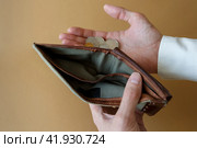 Empty wallet in the hands of a man on a plain background. Стоковое фото, фотограф Aleksandra Selivanova / Фотобанк Лори