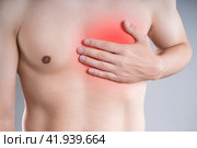 Heart attack, man with chest pain on a gray background, myocardial infarction. Стоковое фото, фотограф Станислав Тарко / Фотобанк Лори