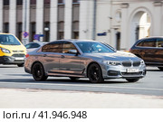 Front side view of BMW 5 series in motion. Shiny gray car moving on the street. Редакционное фото, фотограф Константин Григорьев / Фотобанк Лори