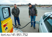 Russia Samara November 5, 2010: mature men refuel a car at an old Rosneft gas station. text in Rosneft. Редакционное фото, фотограф Акиньшин Владимир / Фотобанк Лори