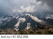 View of the Dzhuguturluchat mountain range of the Great Caucasus Range from the upper station of the cable car of the Dombay ski resort on a summer day, Karachay-Cherkessia, Russia. Стоковое фото, фотограф Ula Ulachka / Фотобанк Лори