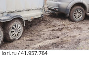 An SUV with a cargo trailer slides through the mud, trying to get out. Seasonal bad weather in rural areas. (2023 год). Редакционное видео, видеограф Коханова Наталья / Фотобанк Лори