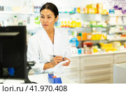 Female pharmacist working in pharmacy, using computer screen. Стоковое фото, фотограф Яков Филимонов / Фотобанк Лори