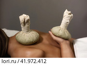 Healthy Thai method herb massaging, herbal compresses bag standing on lady back and hand at massage spa salon, shadow. Relaxing massage for woman back. Relax spa massaging concept. Copy ad text space. Стоковое фото, фотограф Aleksandr Golubev / Фотобанк Лори