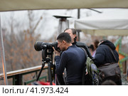 Фотограф на улице с фотографирует со штатива н телеобъектив (2019 год). Редакционное фото, фотограф Оксана / Фотобанк Лори