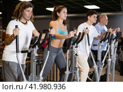 Group of people of different ages train on elliptical trainers steppers. Стоковое фото, фотограф Яков Филимонов / Фотобанк Лори