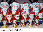 Прилавок игрушечными Дедами Морозами в ассортименте для украшения новогодней елки в магазине города Москвы в предновогодние дни, Россия (2024 год). Редакционное фото, фотограф Николай Винокуров / Фотобанк Лори
