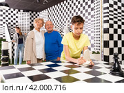 Kids solving riddles in escape room and grandparents watching them. Стоковое фото, фотограф Яков Филимонов / Фотобанк Лори