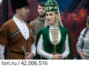 Мужчина и девушка в традиционных национальных костюмах у стенда Карачаево-Черкесской Республики на выставке-форуме "Россия" на ВДНХ в городе Москве, Россия (2024 год). Редакционное фото, фотограф Николай Винокуров / Фотобанк Лори