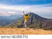 Rear view of lady in yellow jacket arms raised at landmark nature background, Sri Lanka, Ella. Full length of woman enjoy at landscape Adam's peak mountain. Summer vacation concept. Copy ad text space. Стоковое фото, фотограф Aleksandr Golubev / Фотобанк Лори