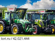 27.07.2019, Kaliningrad Region, Russia: modern agricultural machinery, John Deere tractors with Claas cargo wagons. Редакционное фото, фотограф Долотова Елена Викторовна / Фотобанк Лори