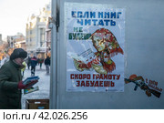 Плакат с надписью "Если книги читать не будешь скоро грамоту забудешь" у букинистической лавки на улице Арбат в городе Москве, Россия (2024 год). Редакционное фото, фотограф Николай Винокуров / Фотобанк Лори