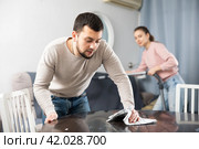 Man wiping furniture with rag while woman hoovering couch. Стоковое фото, фотограф Яков Филимонов / Фотобанк Лори