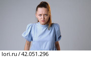 Young woman with clenched fist fighting for change, justice on gray background. Стоковое видео, видеограф Сергей Толмачёв / Фотобанк Лори