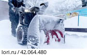 A man cleans snow with a snow plow outside. Стоковое фото, фотограф Igor Skripachev / Фотобанк Лори