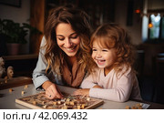 Smiling mother and little daughter playing logic strategy wooden board game at kitchen table together, caring mom teaching adorable kid girl, happy family engaged in educational activity at home. Стоковое AI-изображение, AI-художник Ирина Михайличенко / Фотобанк Лори