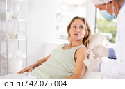Blurry mature male nurse gives injection, injects vaccine into shoulder of woman patient of clinic. Стоковое фото, фотограф Яков Филимонов / Фотобанк Лори
