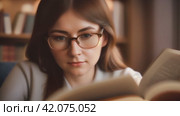 A smart girl reads a book with enthusiasm, enjoying the world of knowledge and stories. Стоковое AI-видео, аниматор Юрий Поздников / Фотобанк Лори